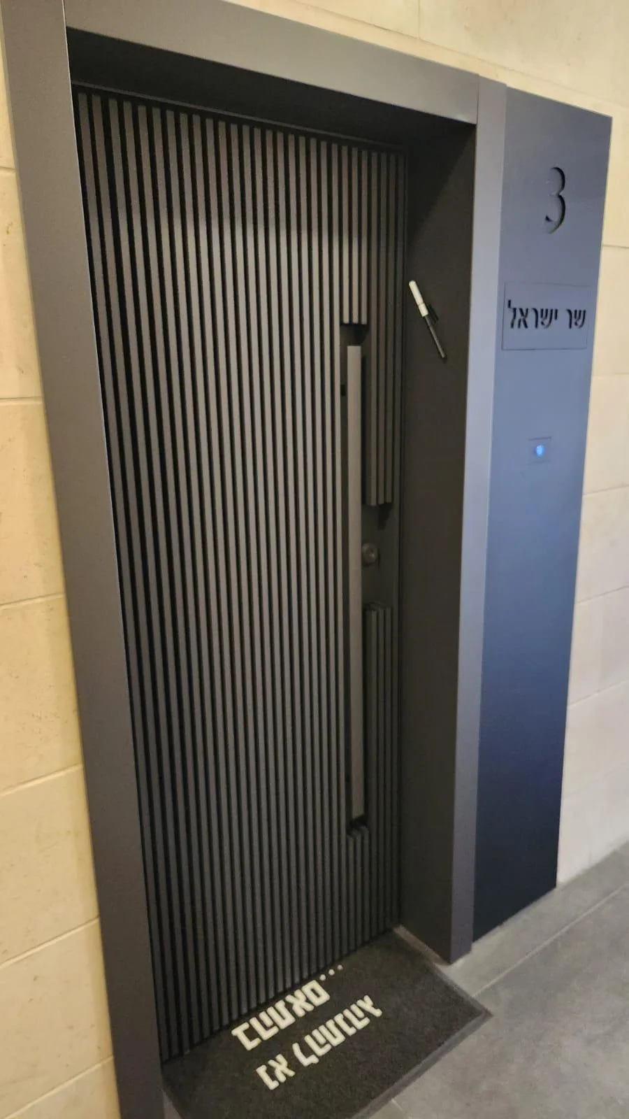 דלת כניסה יוקרתית עם חיפוי עץ כהה.